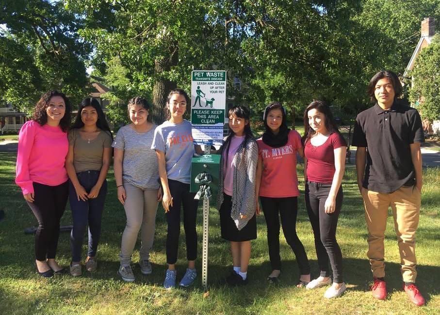 Trio Upward Bound students next to a pet waste station they installed